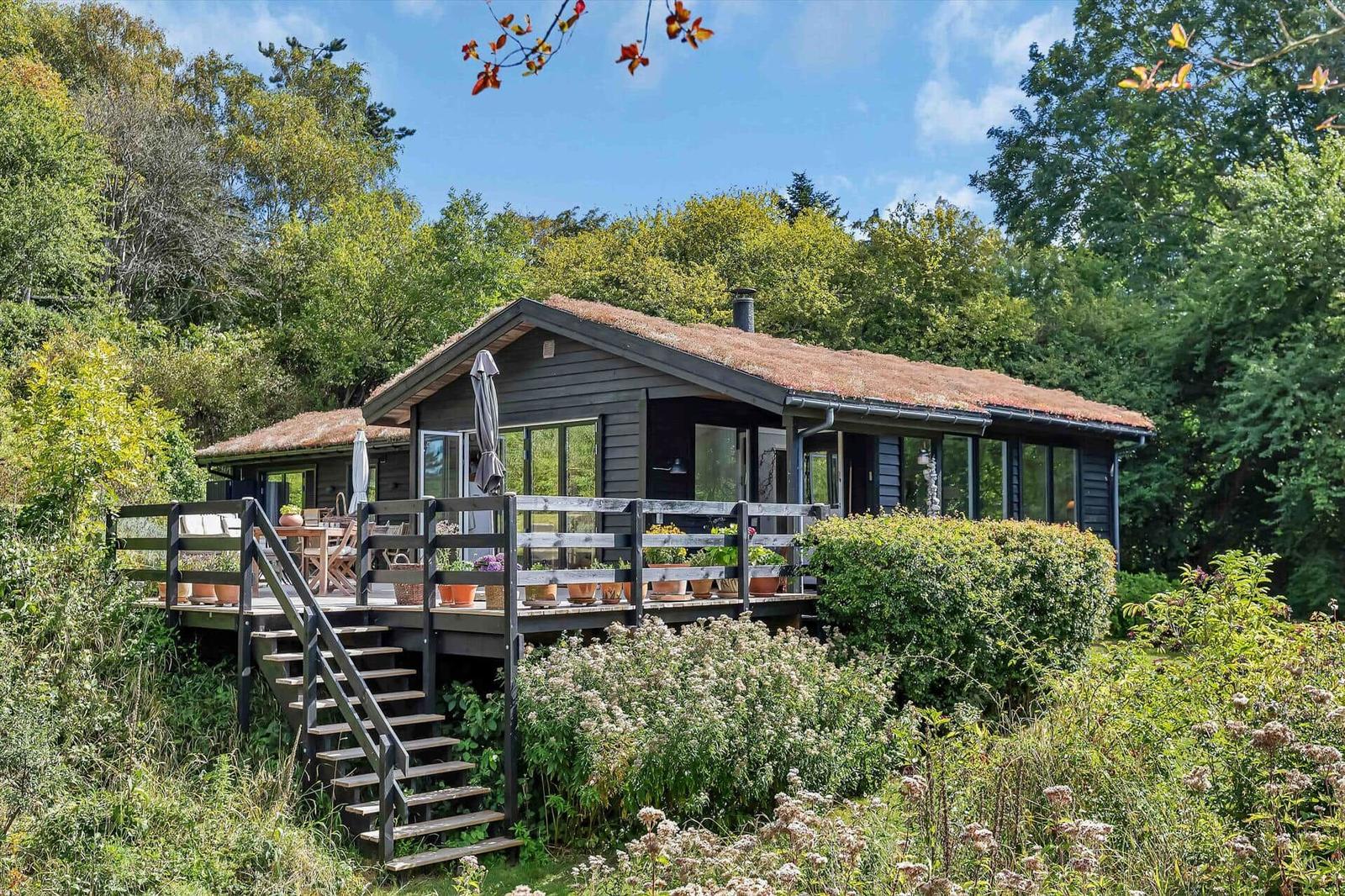 Holzhütte mit Terrasse und Garten in grüner Umgebung