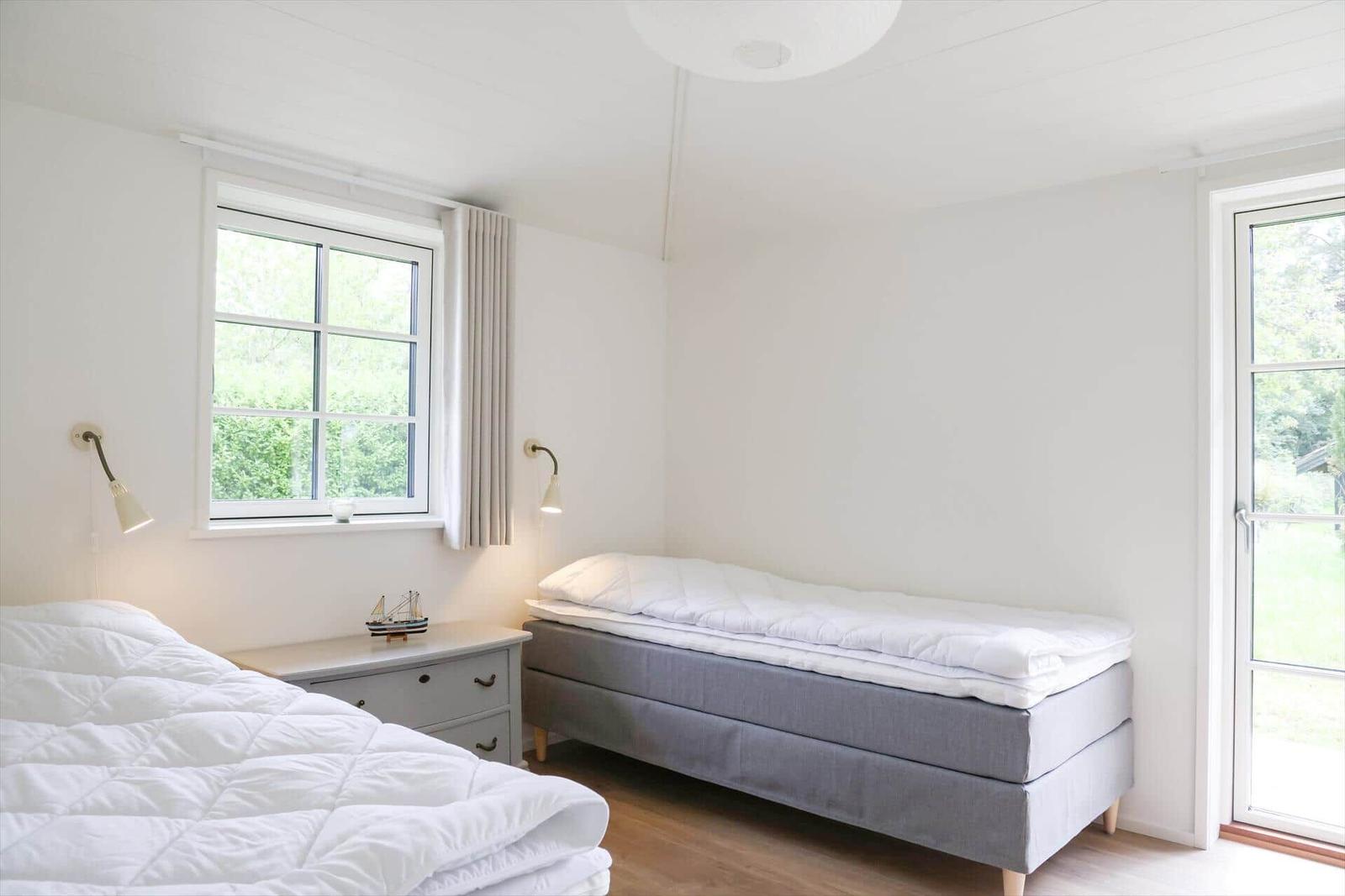 Zimmer mit zwei Betten, Fenster und Tür zum Garten.