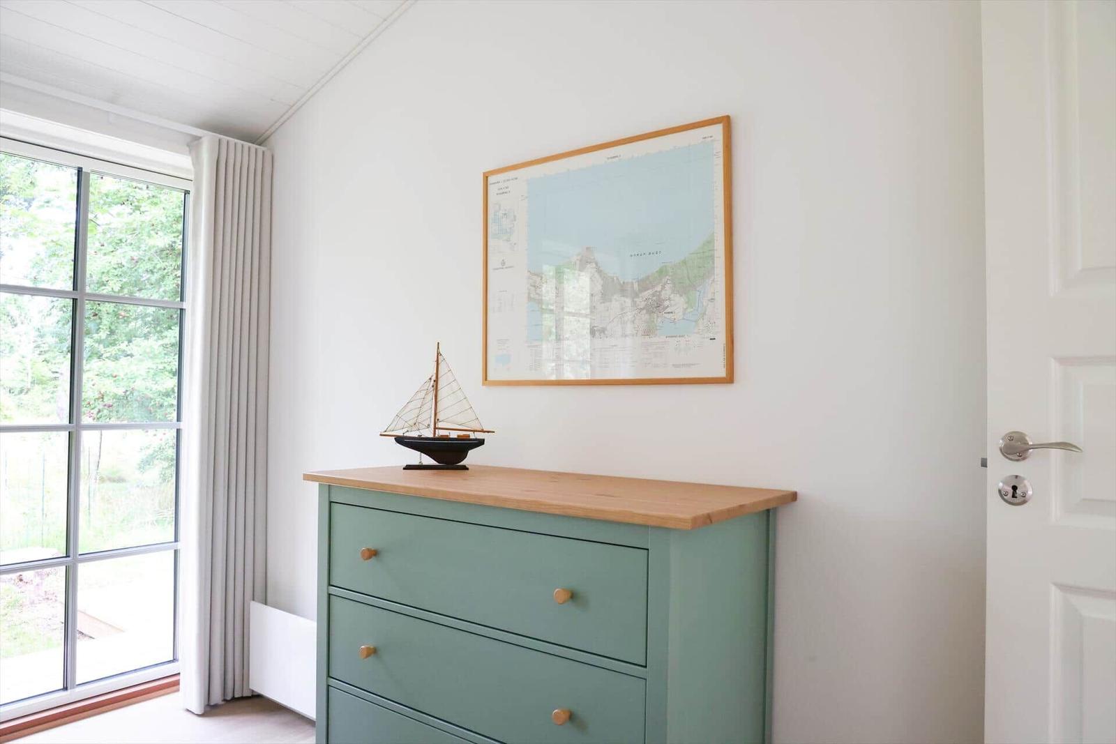 Schrank mit Segelschiffmodell und Karte an der Wand