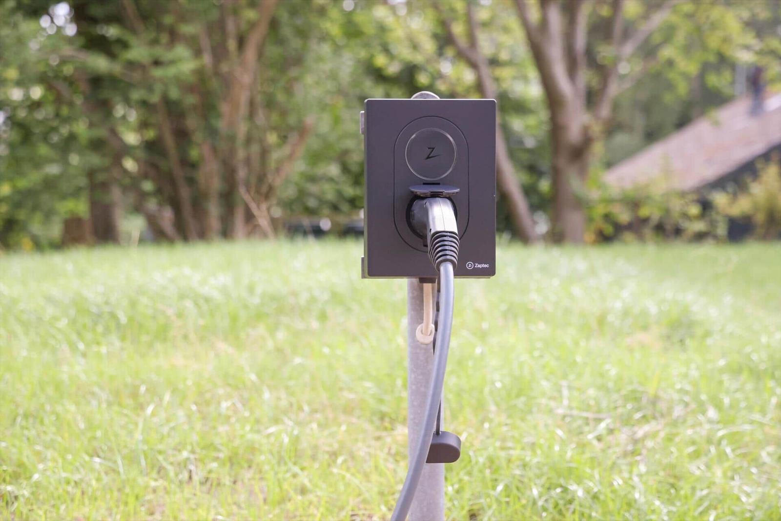 Ladestation im Garten mit Stromkabel und Stecker