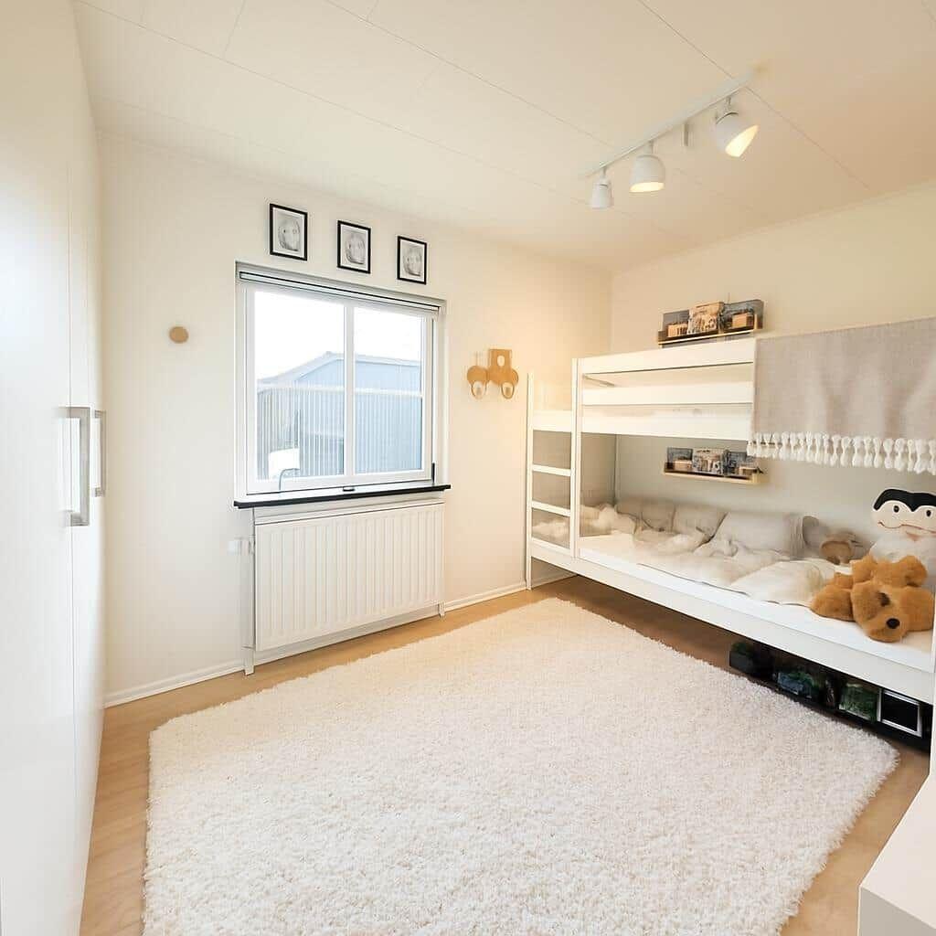 Zimmer mit Doppelstockbett, Fenster und Teppichboden.