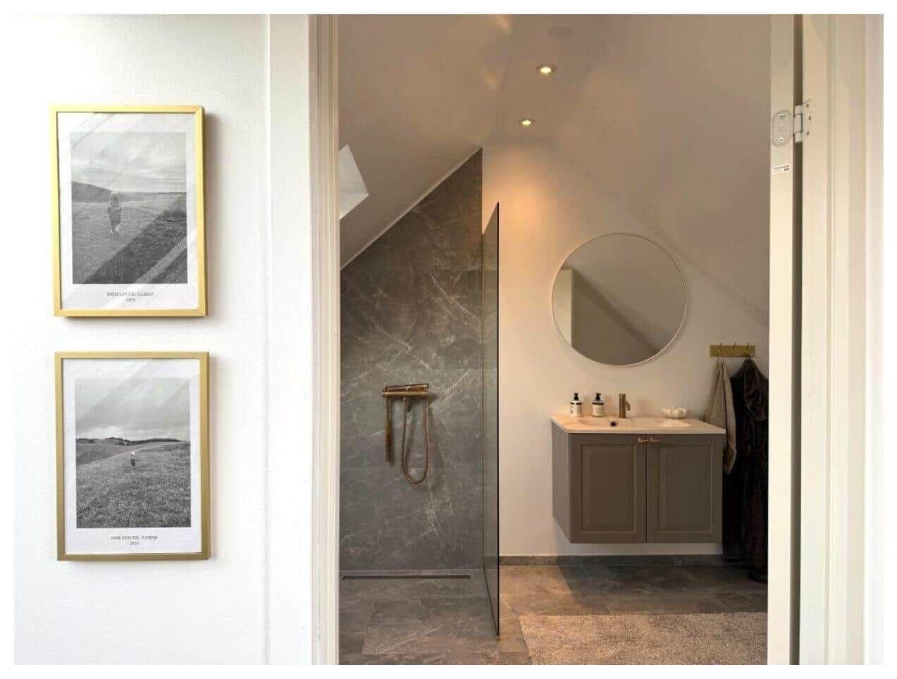 Badezimmer mit Dusche, Waschbecken und runden Spiegel