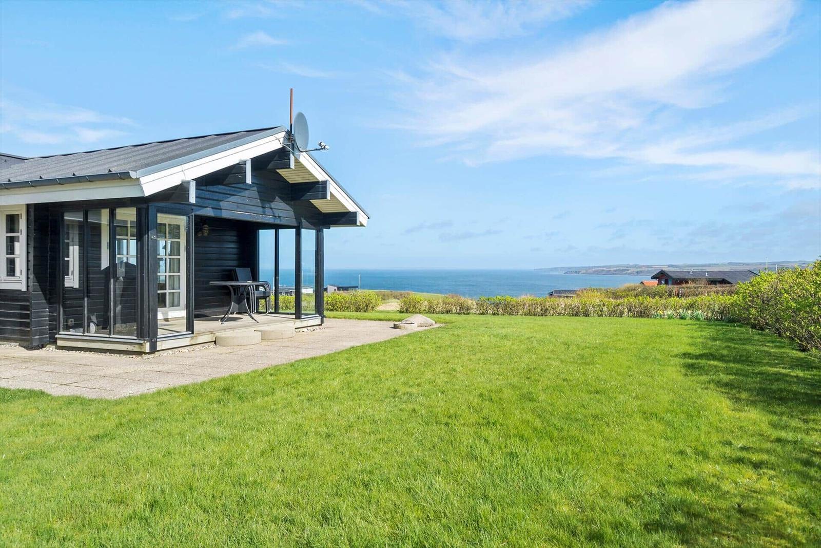 Schwarzes Haus mit Terrasse und Blick auf das Meer