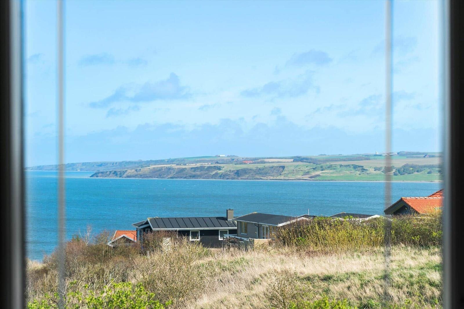 Blick aus dem Fenster auf das Meer und die Küstenlandschaft.