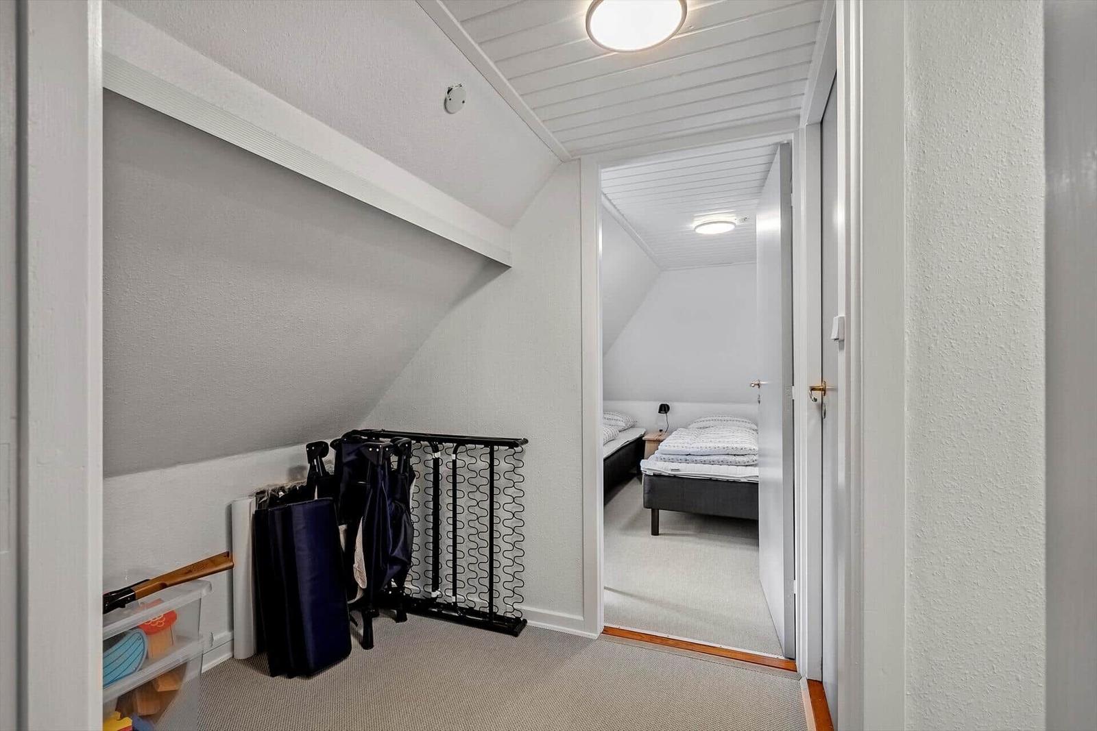 Flur mit Schlafzimmer im Hintergrund und Kinderzubehör im Vordergrund.