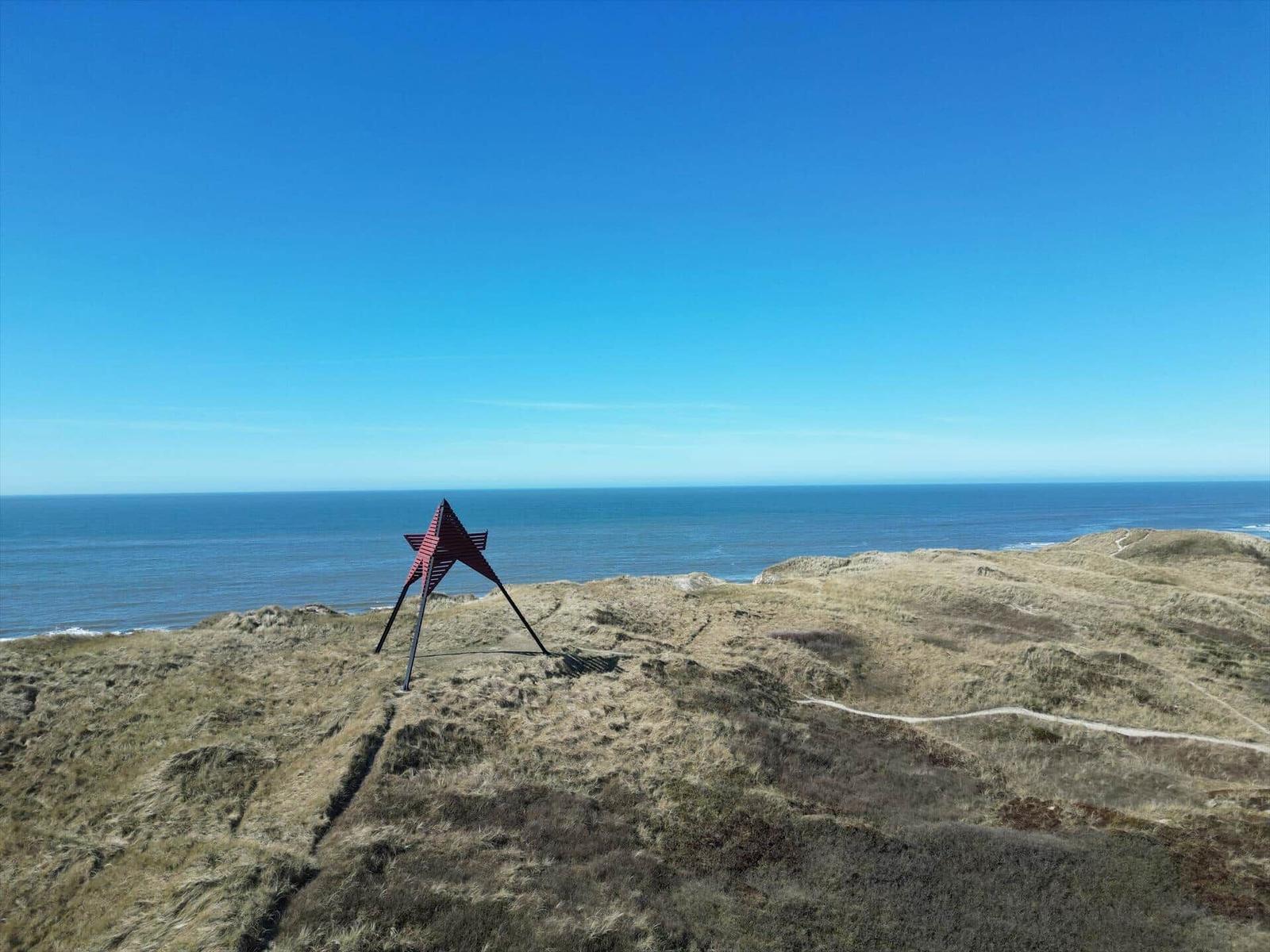 Roter Stern auf Hügel mit Meerblick