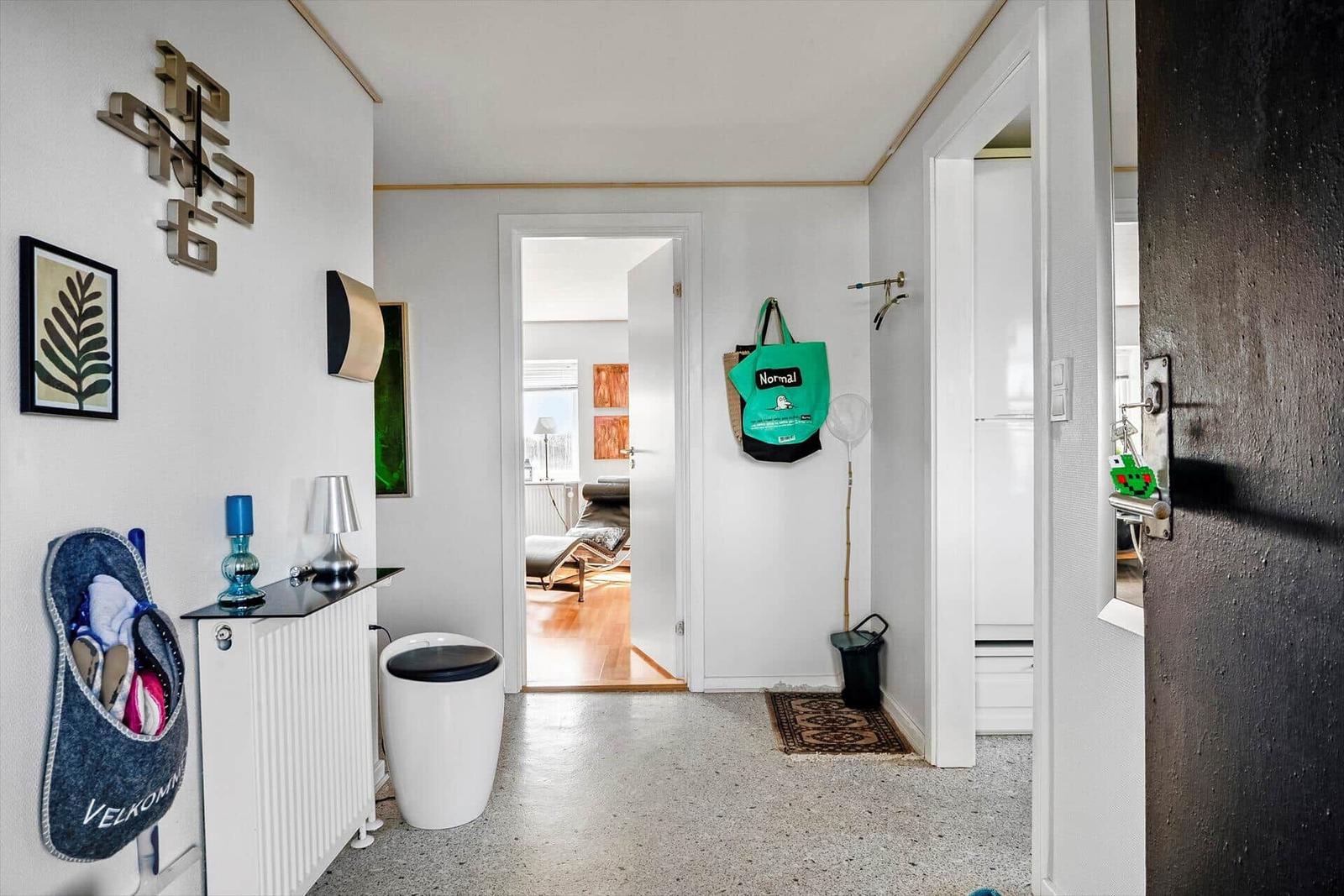 Hausgang mit Eingangsbereich, Wanddekoration und Sicht in Wohnzimmer und Küche.