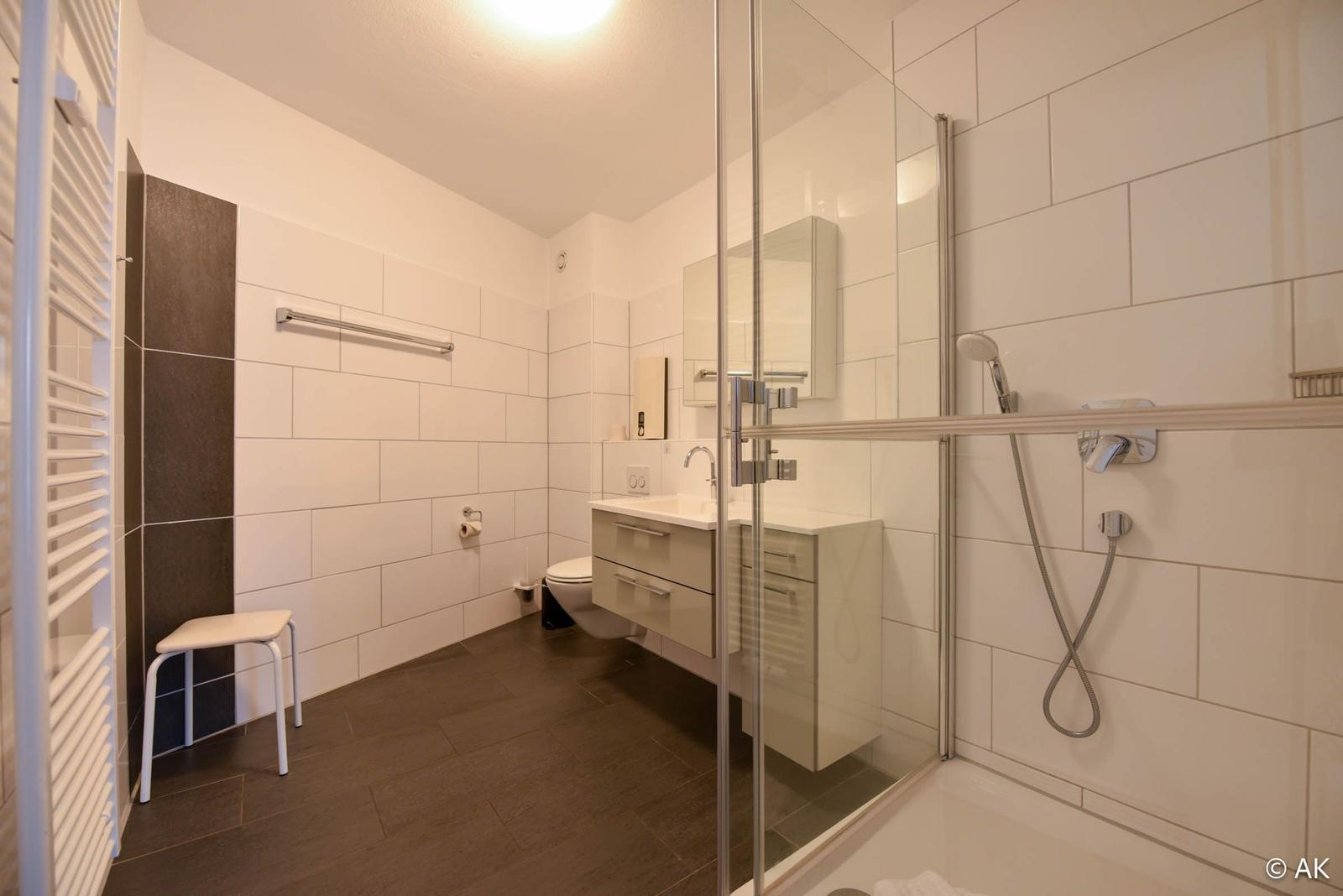 Badezimmer mit Dusche, Waschbecken und Toilette