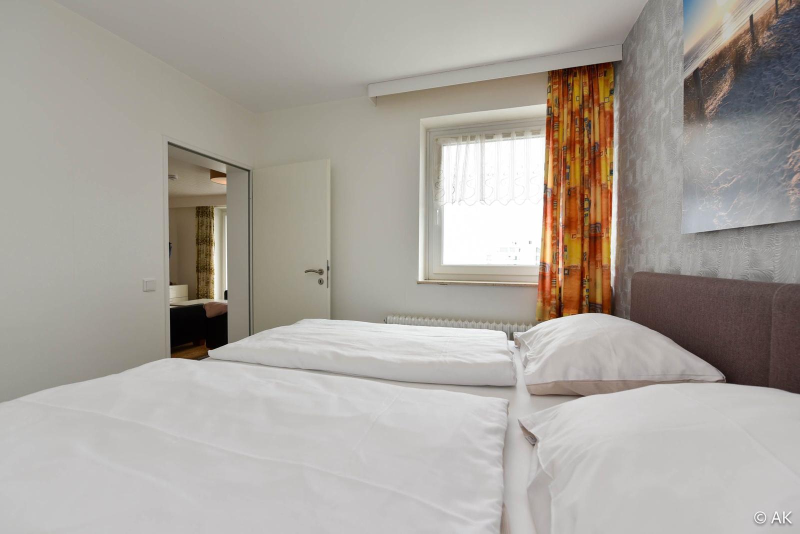 Schlafzimmer mit Bett, Fenster und Wandbild