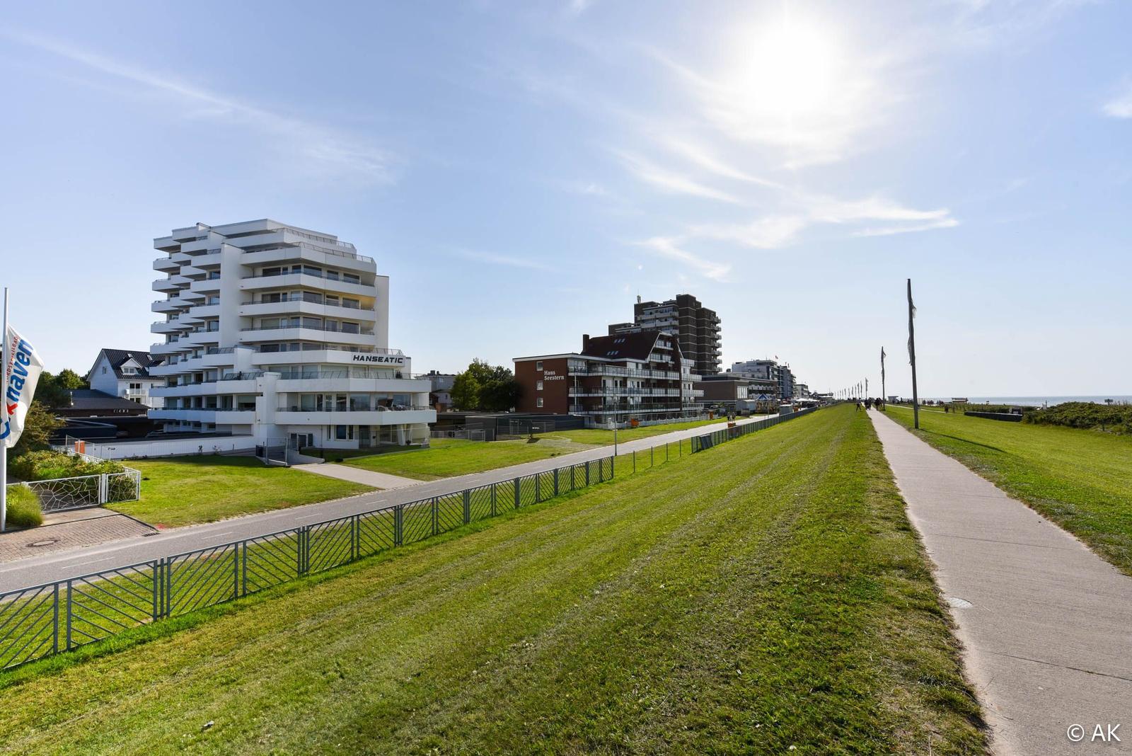 Grüner Strandweg mit Hotels und Blick aufs Meer.
