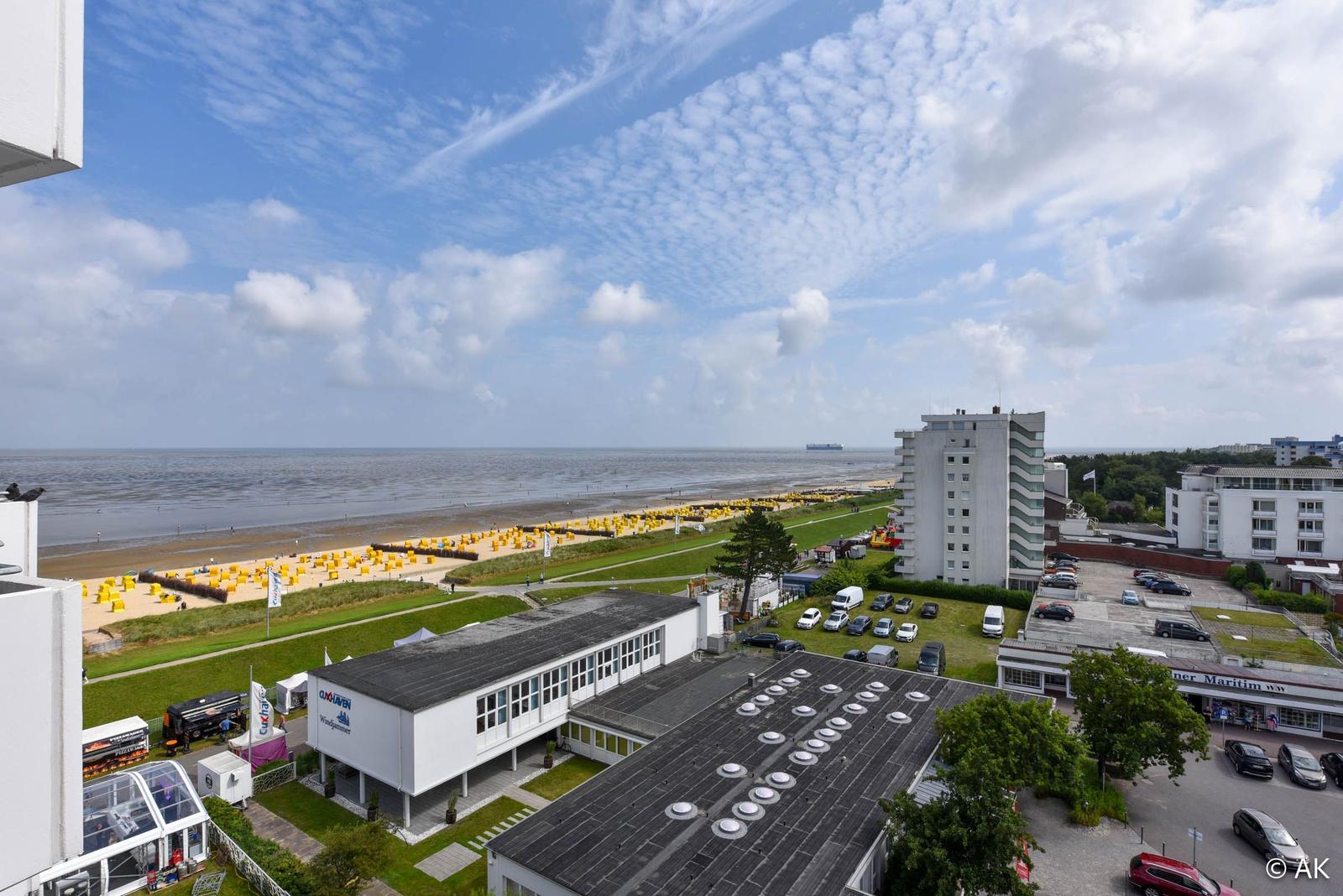 Blick auf Strand mit gelben Strandkörben und Hotelanlage.