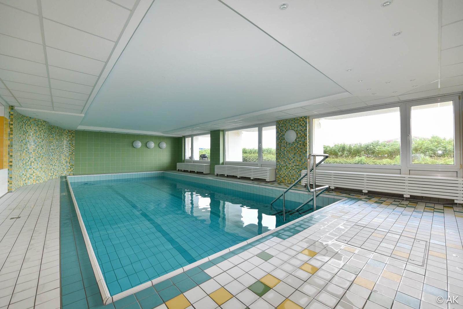 Innere Schwimmhalle mit Pool, Fenstern und Bänken