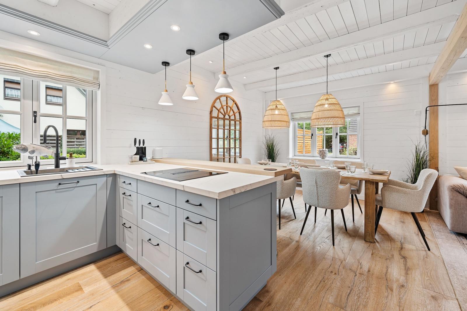 Küche mit Essbereich, Holzboden und weißen Wänden.