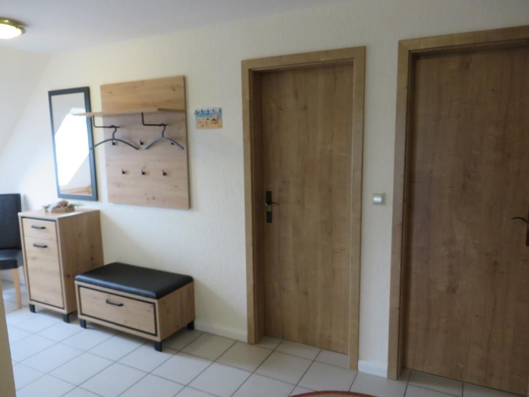 Eingangsbereich mit Schuhschrank, Spiegelschrank und zwei Türen.