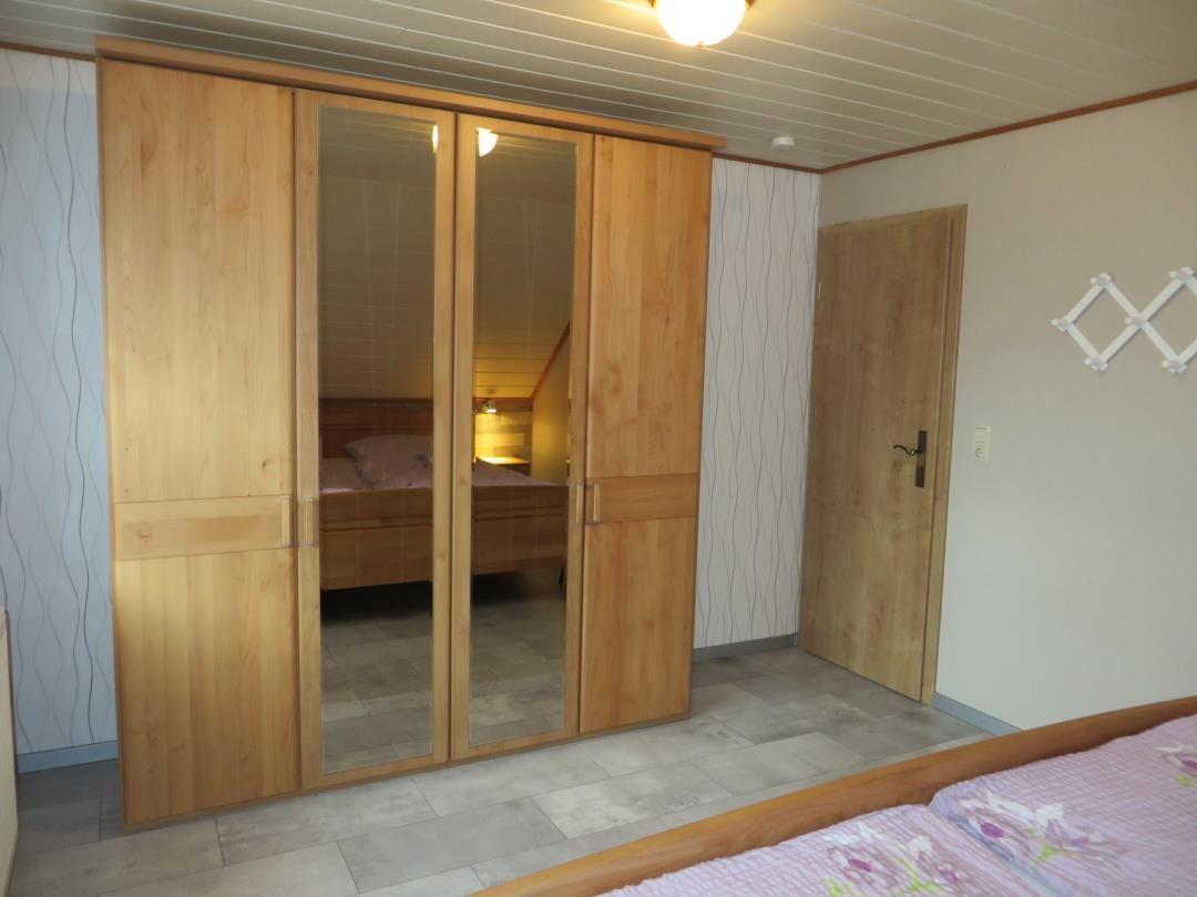 Schlafzimmer mit Holzschrank und Spiegeltüren, Tür und Wandverkleidung