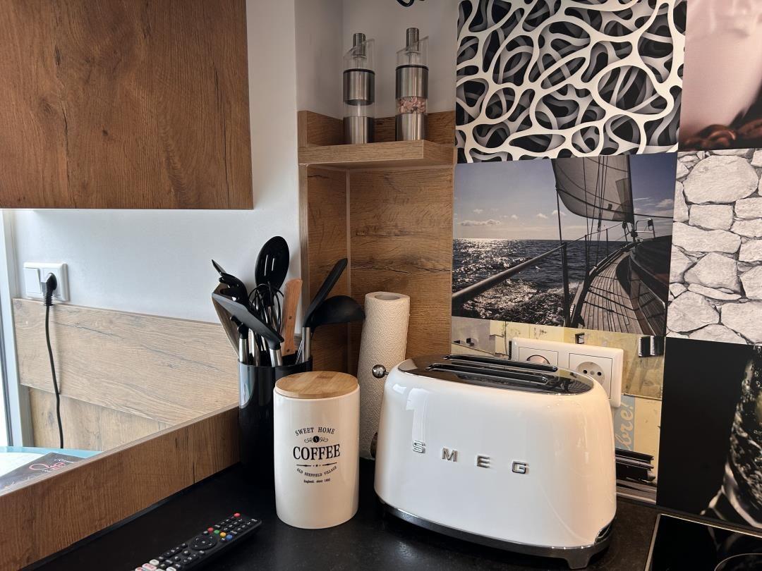 Küchenbereich mit Toaster, Kaffeetasse und Küchenutensilien.