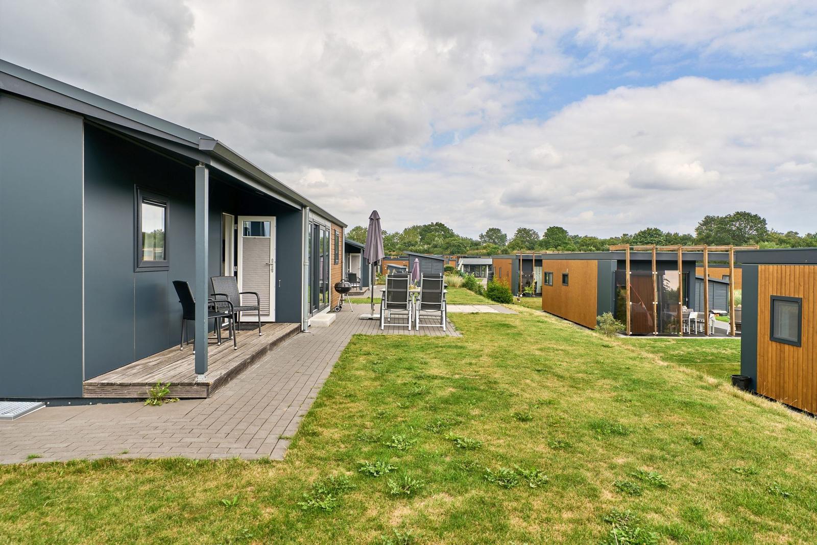 Moderne Ferienhäuser mit Terrassen und Gartenbereich.