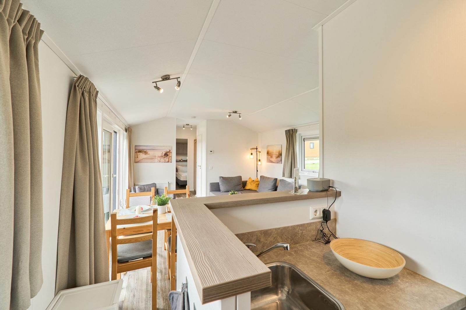 Küche mit Essbereich und Wohnzimmer im Hintergrund.