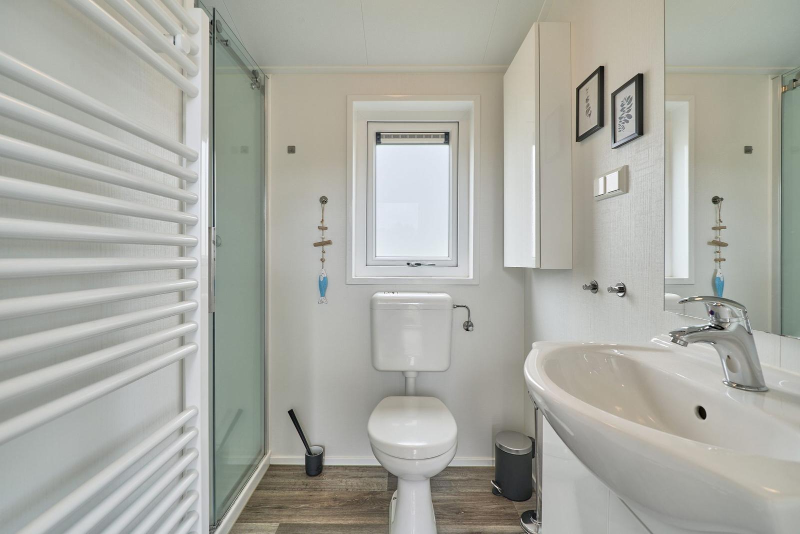 Badezimmer mit Dusche, Toilette und Waschbecken.