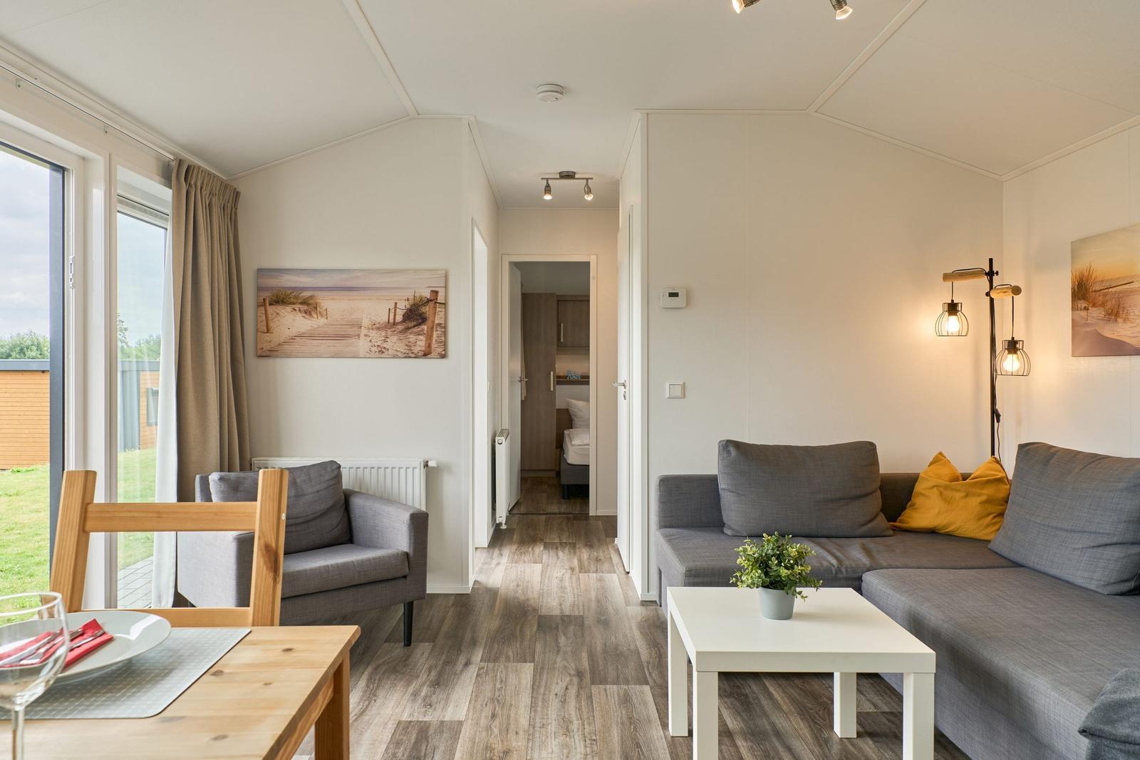 Wohn- und Essbereich mit Sofa, Tisch und Blick auf Garten