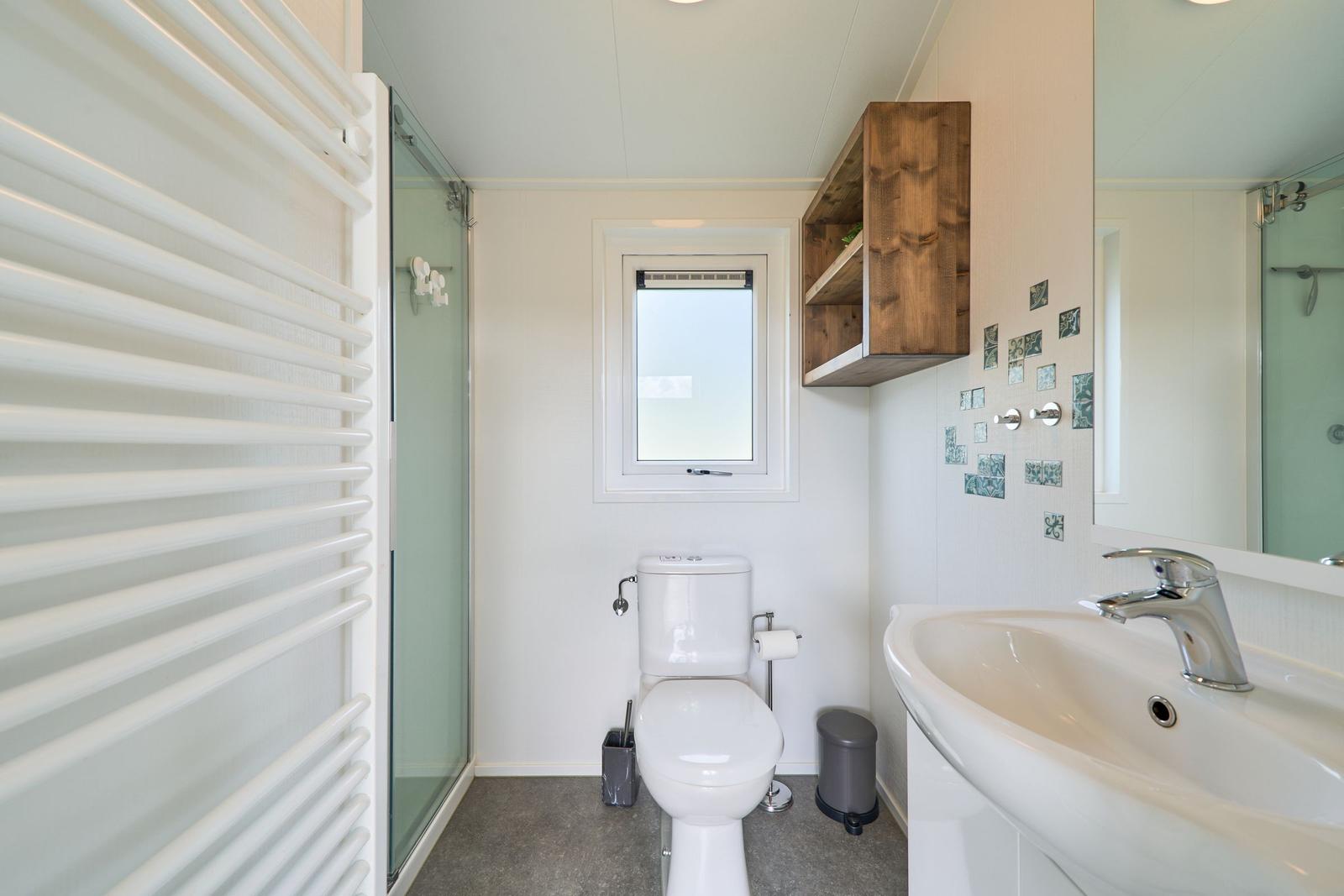 Badezimmer mit Dusche, Toilette und Waschbecken.
