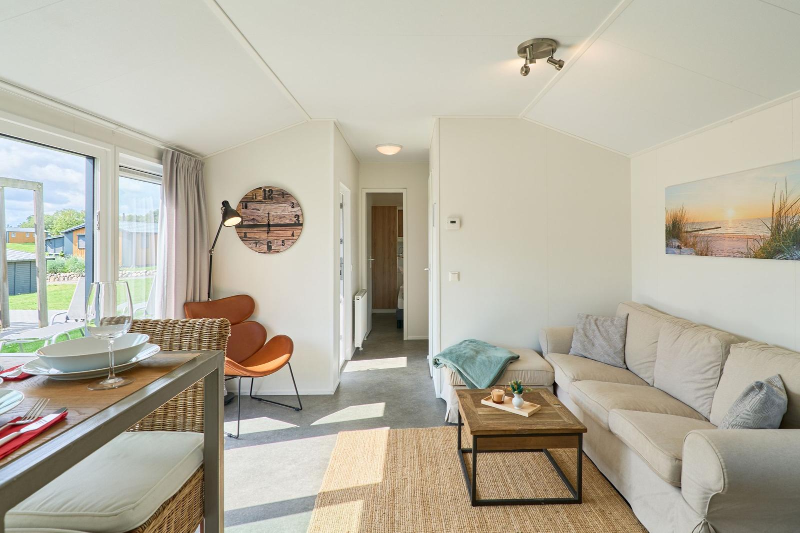Wohnbereich mit Sofa, Esstisch und Blick auf Garten