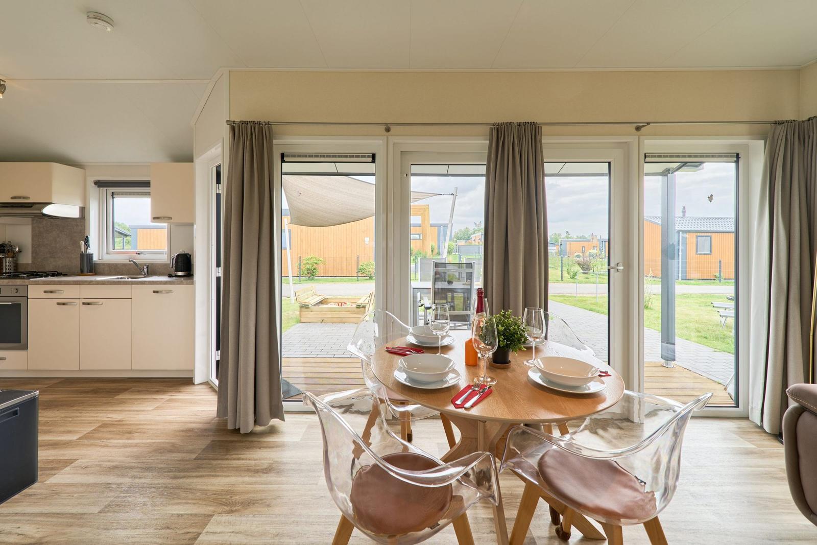 Essbereich mit Tisch und Stühlen, Blick auf Terrasse und Garten.