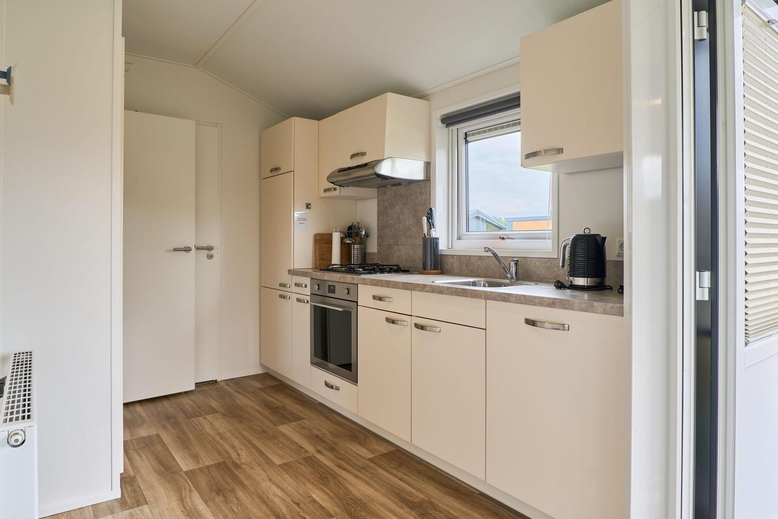 Küche mit Arbeitsplatte, Spüle, Herd und Kühlschrank.