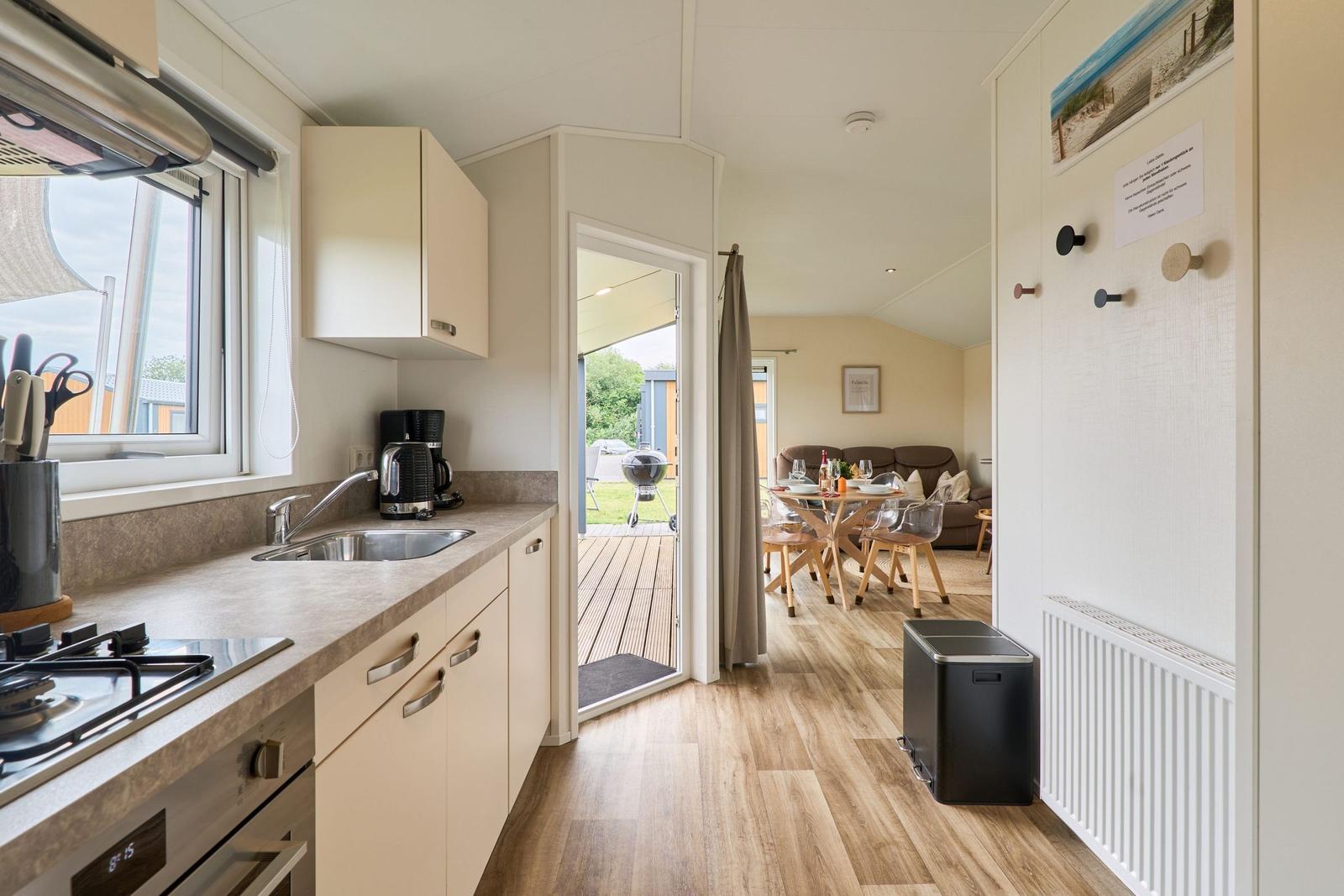 Küche mit Blick auf Terrasse und Essbereich mit Sofa und Tisch.