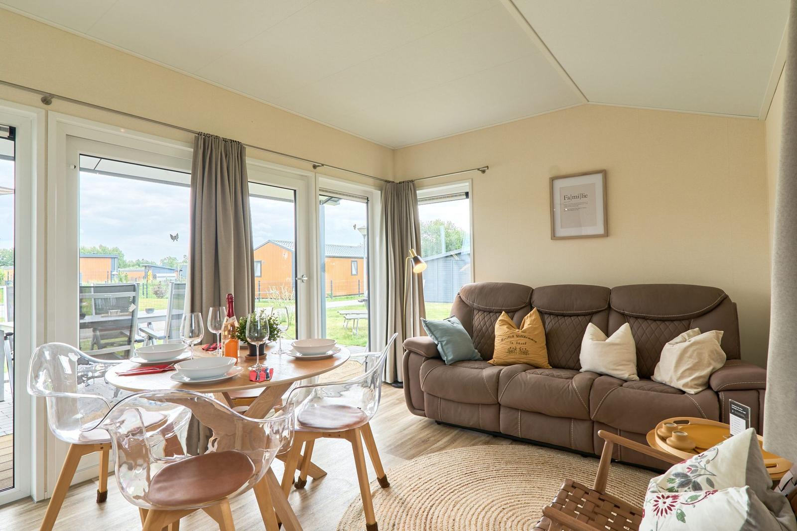 Wohn- und Essbereich mit Sofa, Tisch und Sicht auf den Garten.