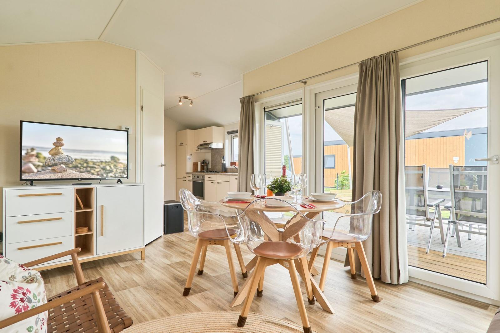 Wohnküche mit Esstisch, TV und Blick auf Terrasse