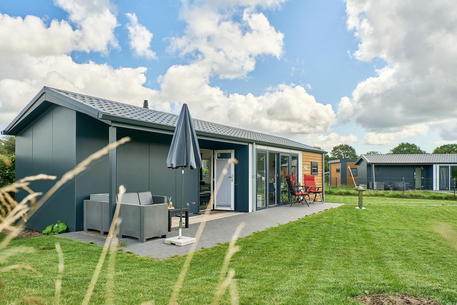 Moderne Ferienwohnung mit Terrasse, Garten und Sitzgelegenheiten.