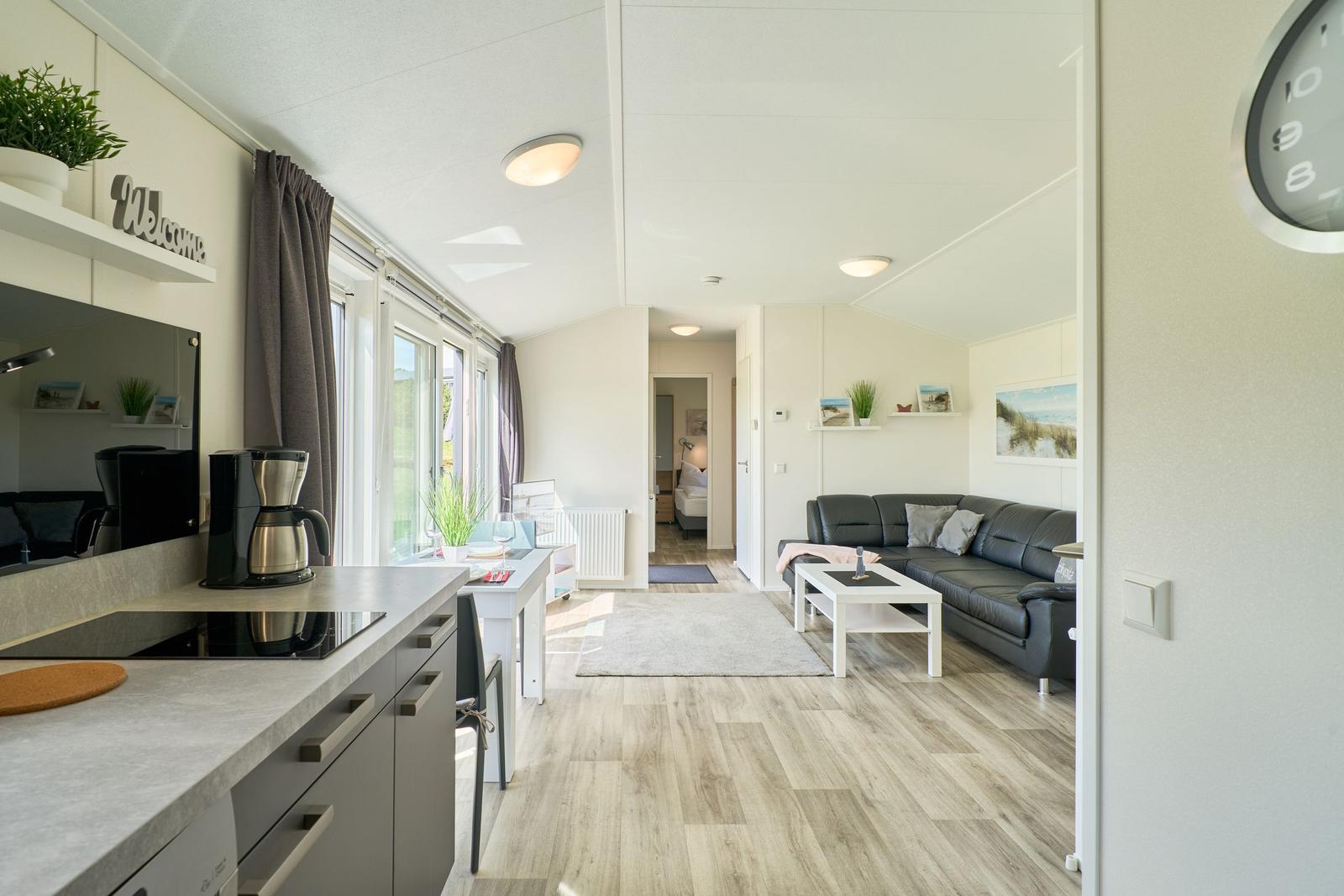 Küche mit Esstisch, Wohnbereich mit Sofa und Blick in Schlafzimmer