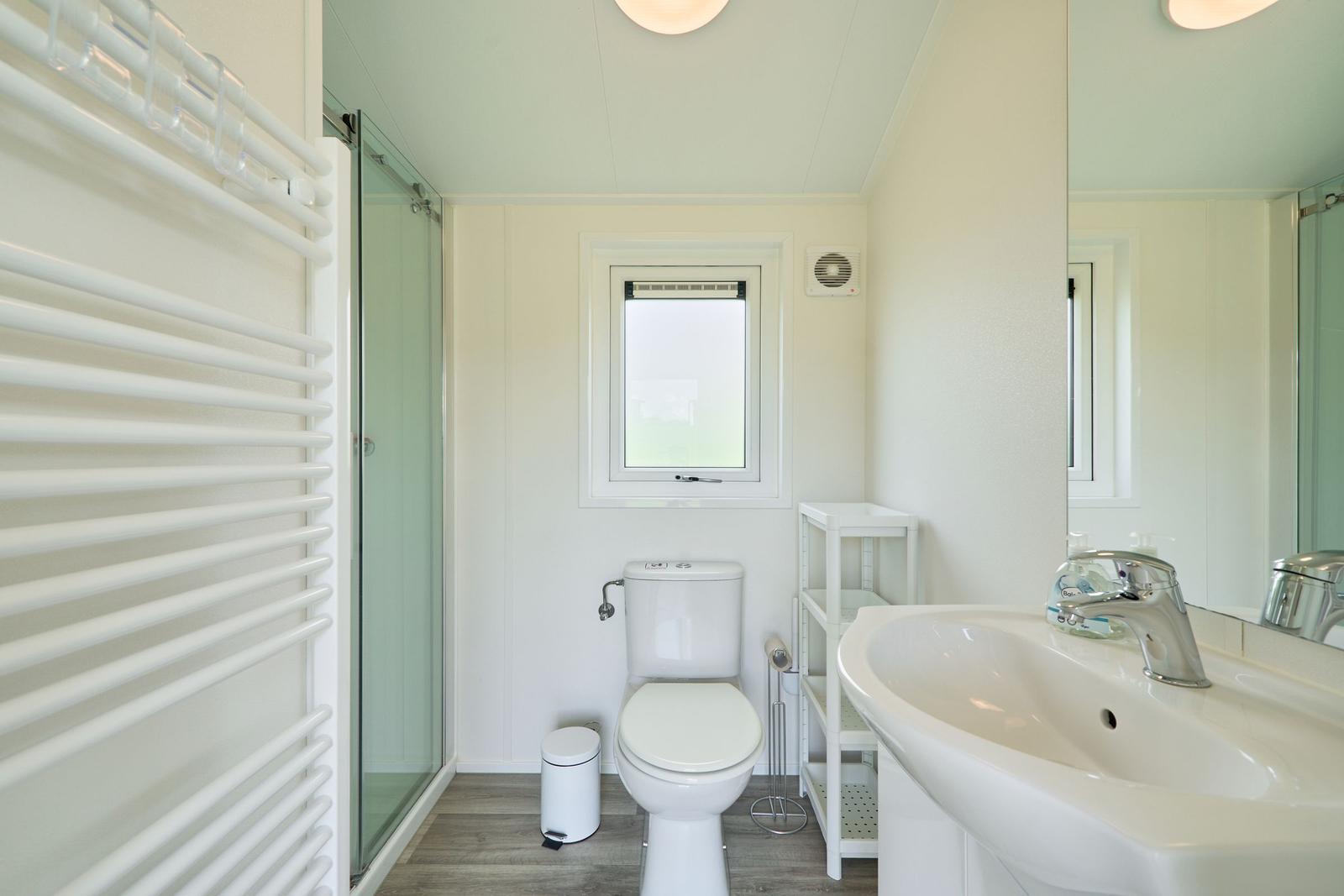 Badezimmer mit Dusche, Toilette und Waschbecken.