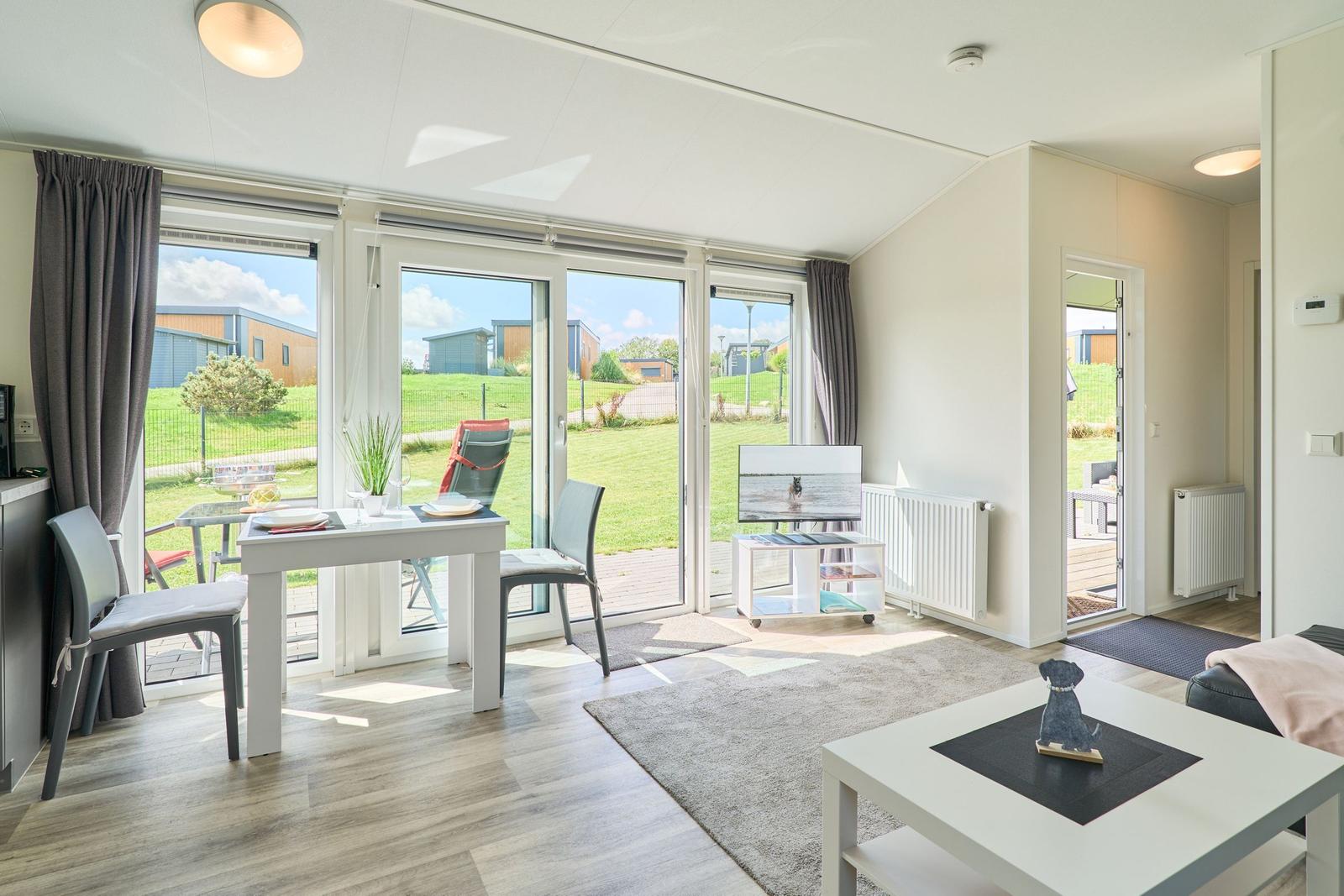 Wohn- und Essbereich mit Glasfront zur Terrasse und Garten.