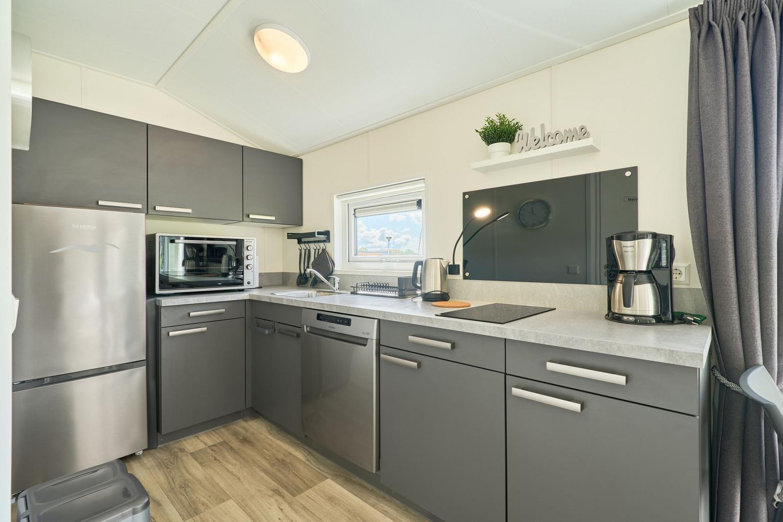 Küche mit Kühlschrank, Spülmaschine und Kochfeld.