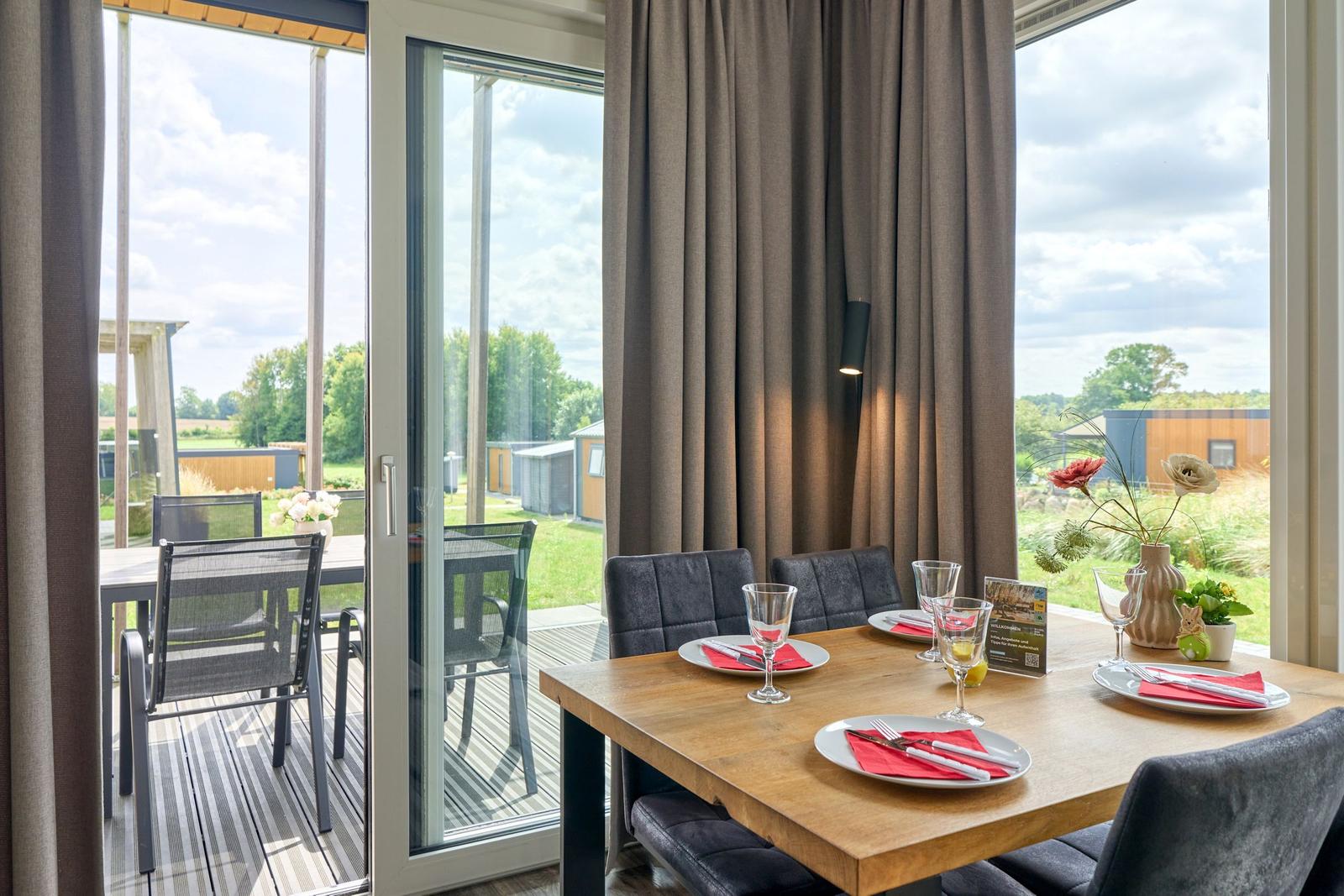 Esstisch mit Stühlen und Blick auf die Terrasse.