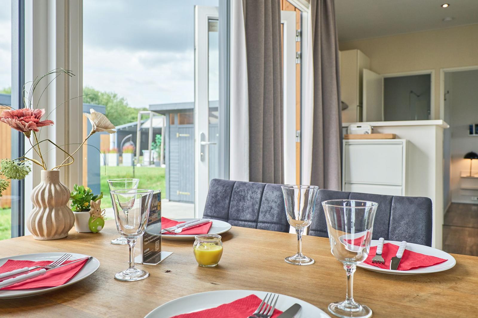 Esstisch mit Platz für vier Personen, Blick auf Garten und Terrasse.