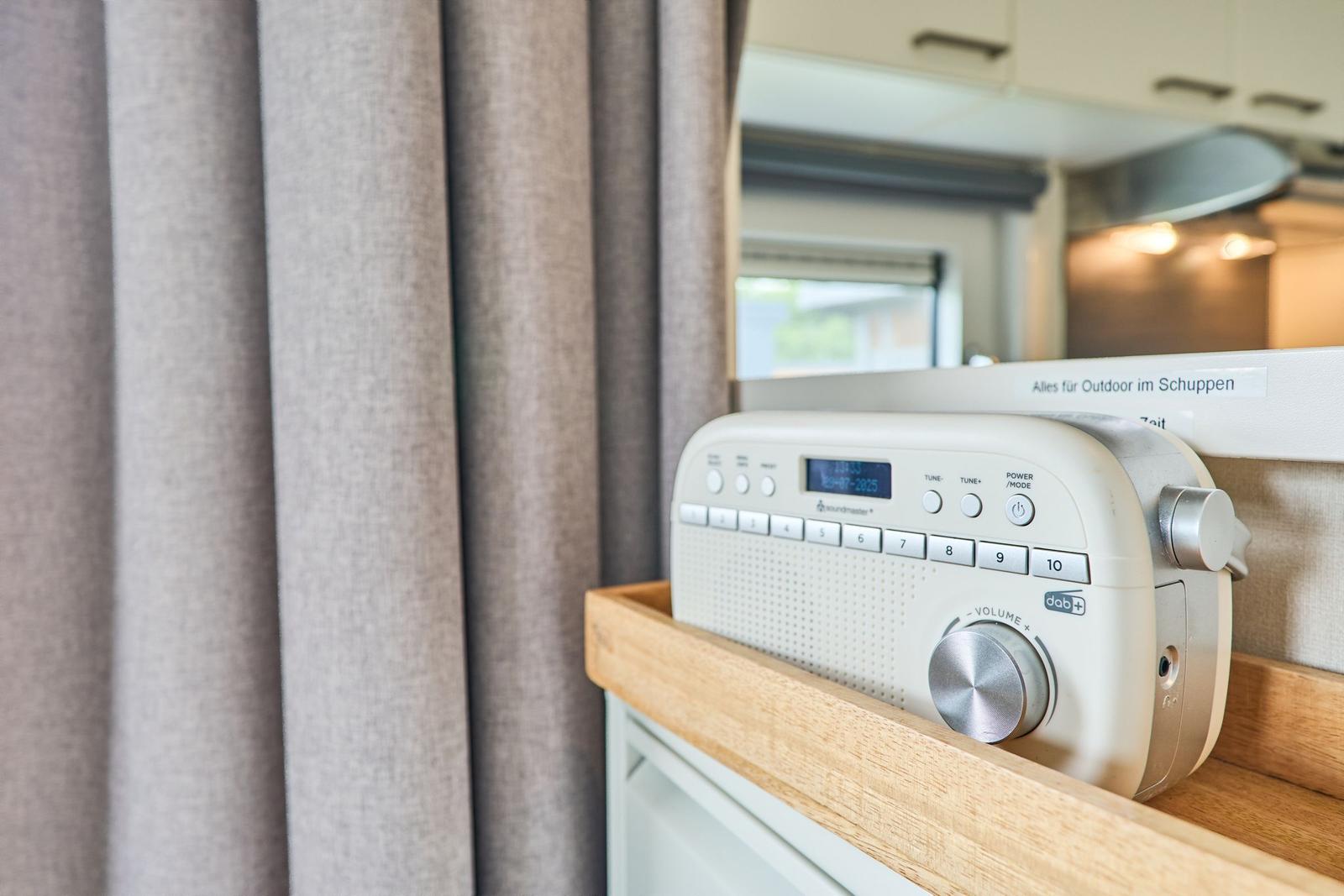 Radio auf Holzregal neben Vorhang im Wohnbereich
