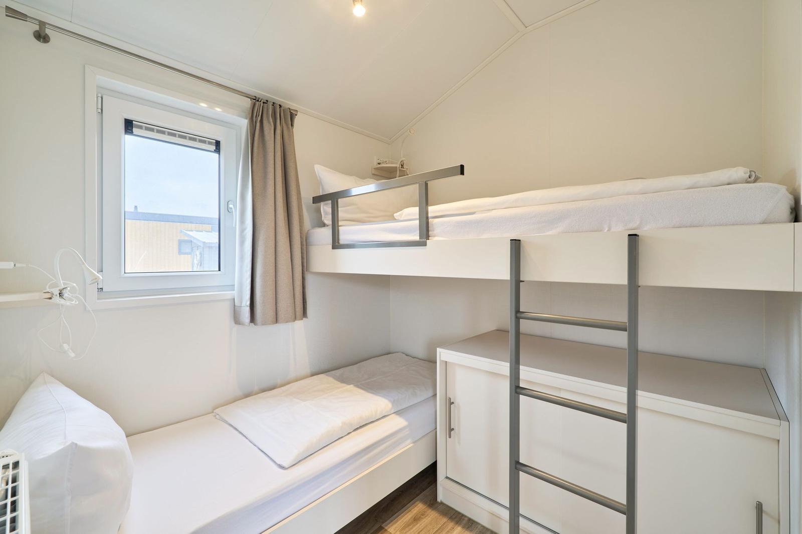 Zimmer mit Doppelstockbett, Fenster und Schrank