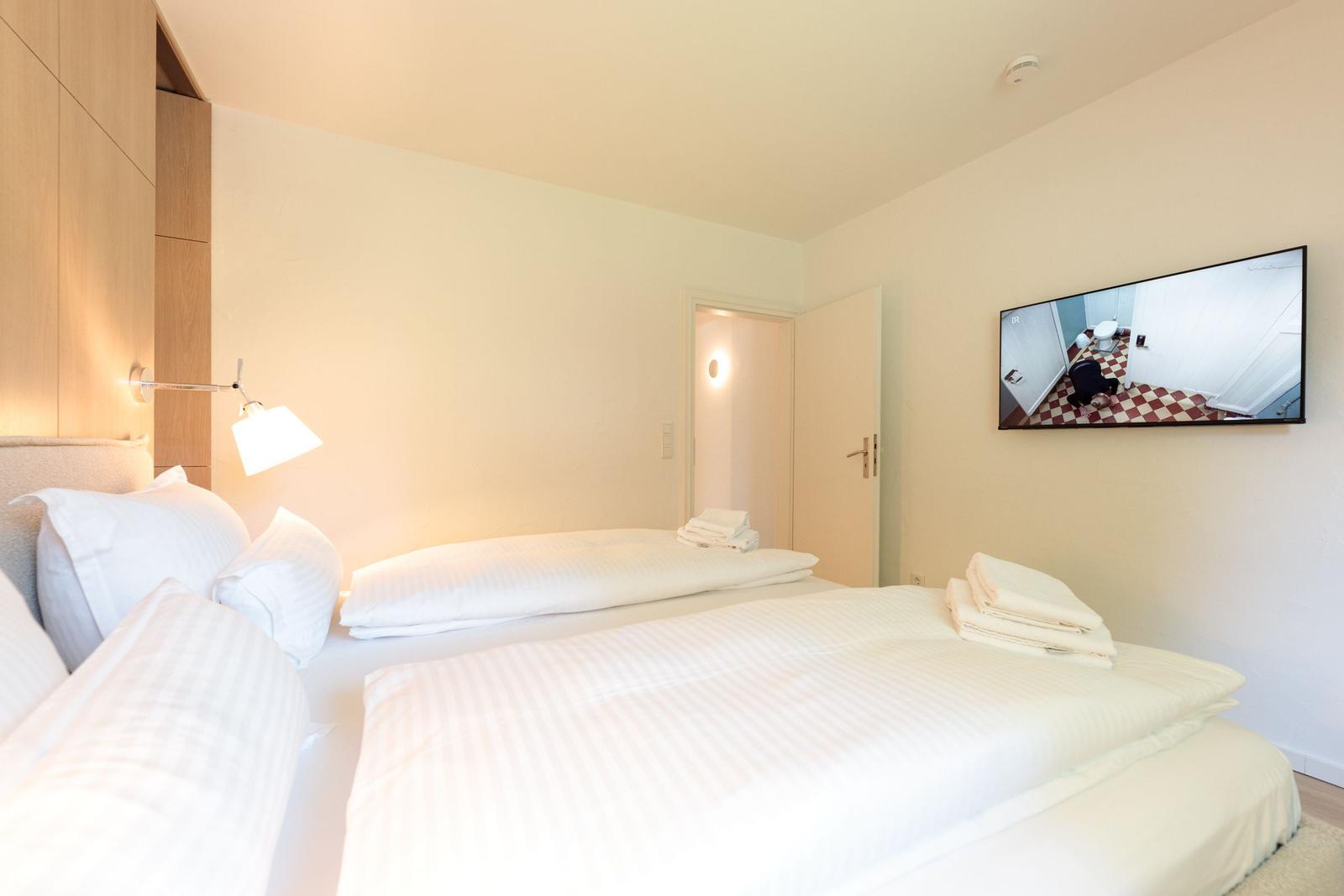 Schlafzimmer mit Doppelbett, TV und integriertem Schrank