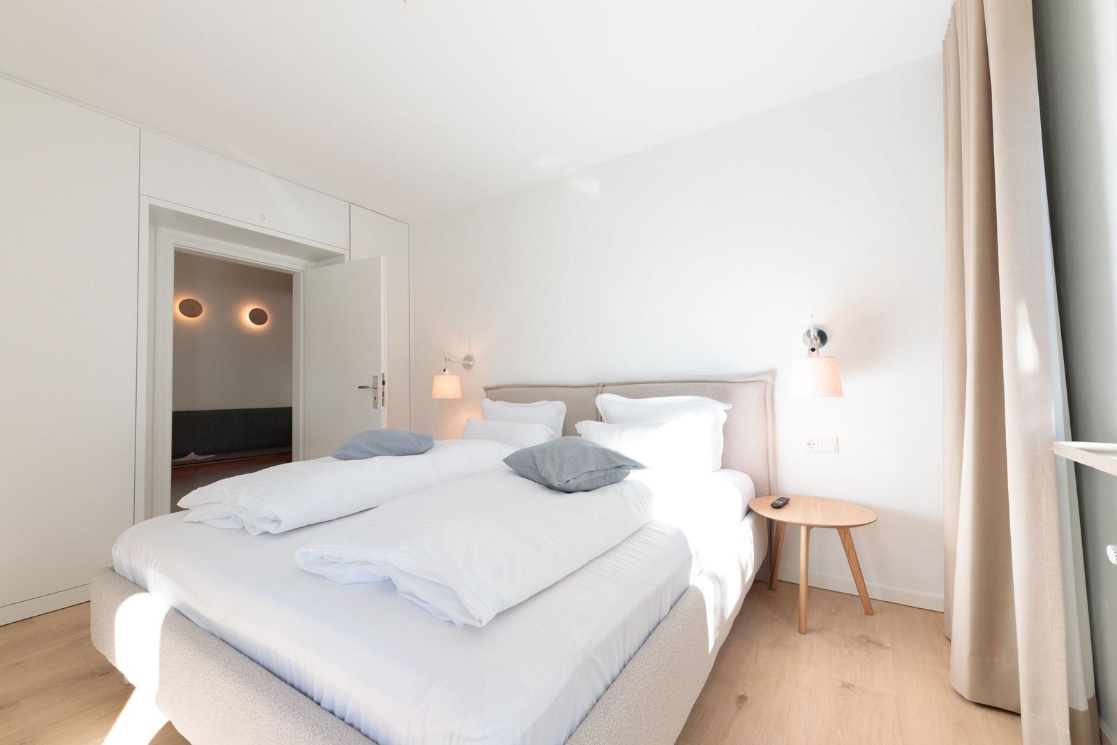 Schlafzimmer mit Doppelbett, Nachttisch und Lichtschalter