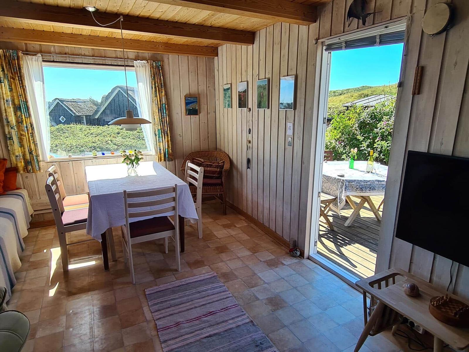 Dining room with table, chairs, and view of balcony and landscape.