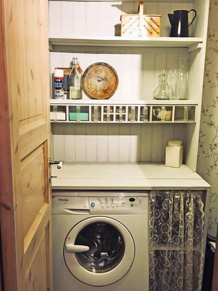 Waschmaschine unter Holzregal mit Geschirr und Flaschen