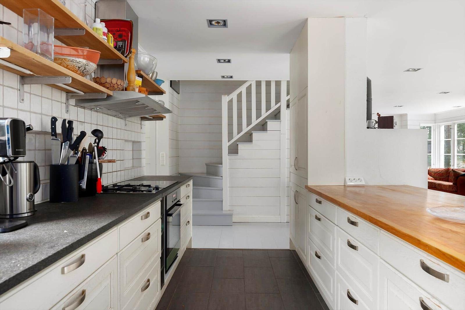 Küche mit Arbeitsplatte, Schränken und Stufen zur Treppe