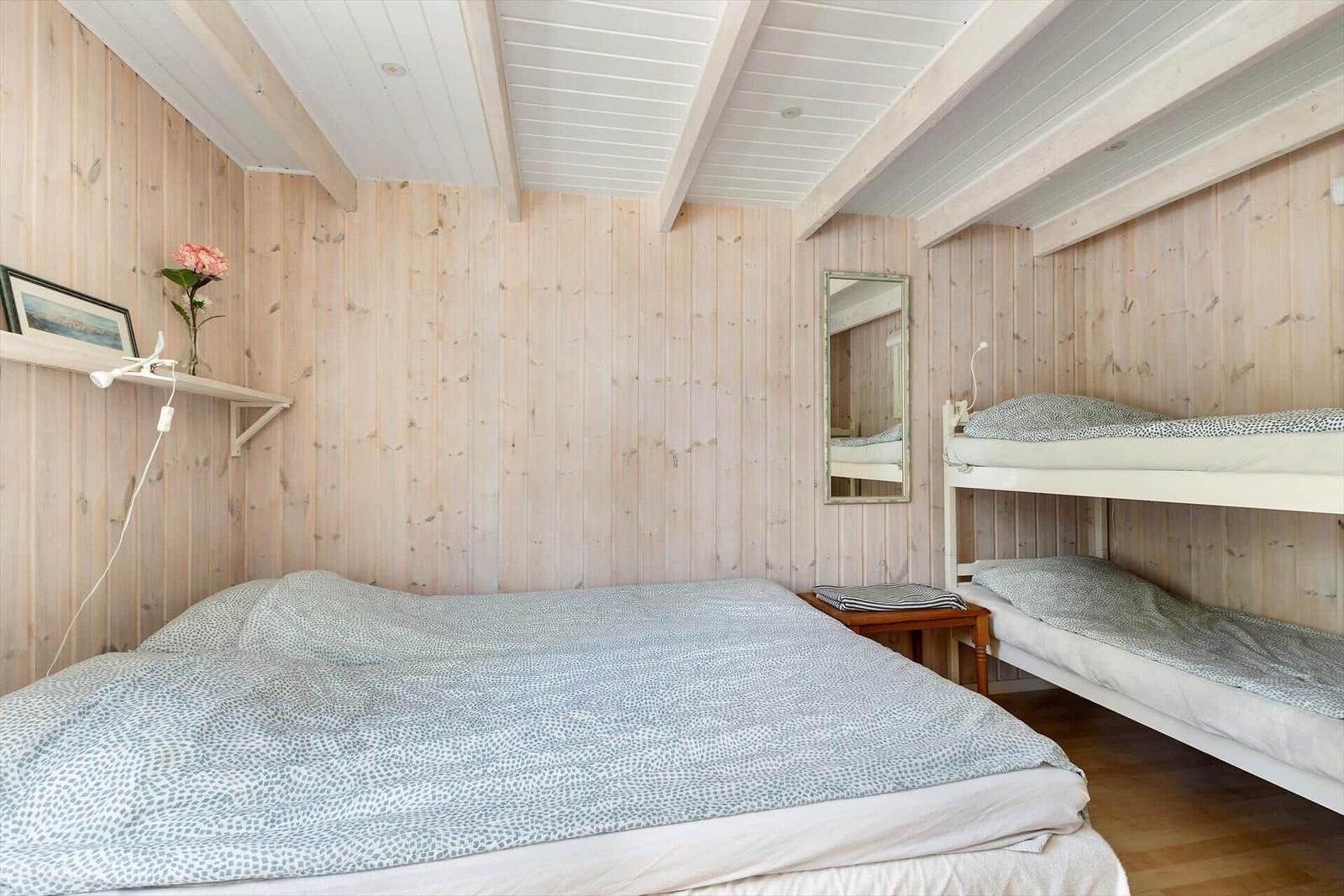 Zimmer mit Doppelbett und Schlafcouch, Holzwände und Spiegel