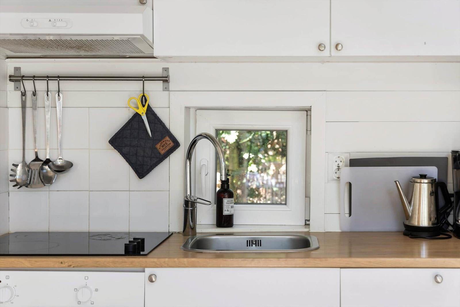 Küche mit Spüle, Herd und Fenster zum Garten