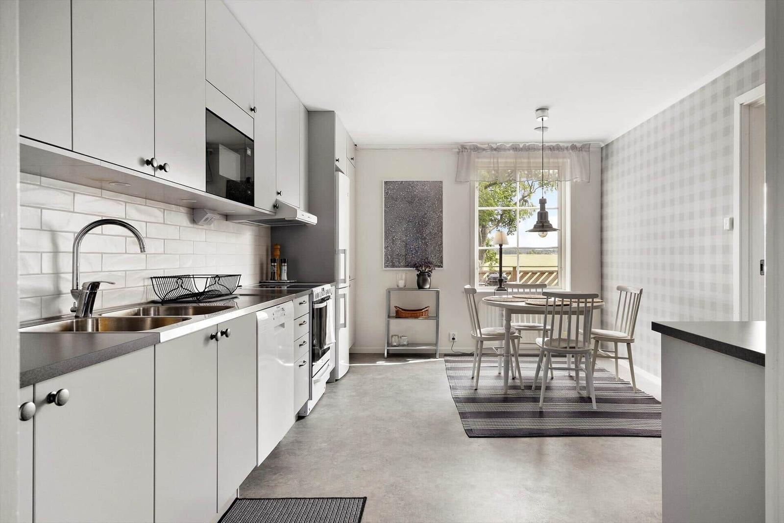 Küche mit Essbereich, weißer Arbeitsfläche und Fenster mit Blick.
