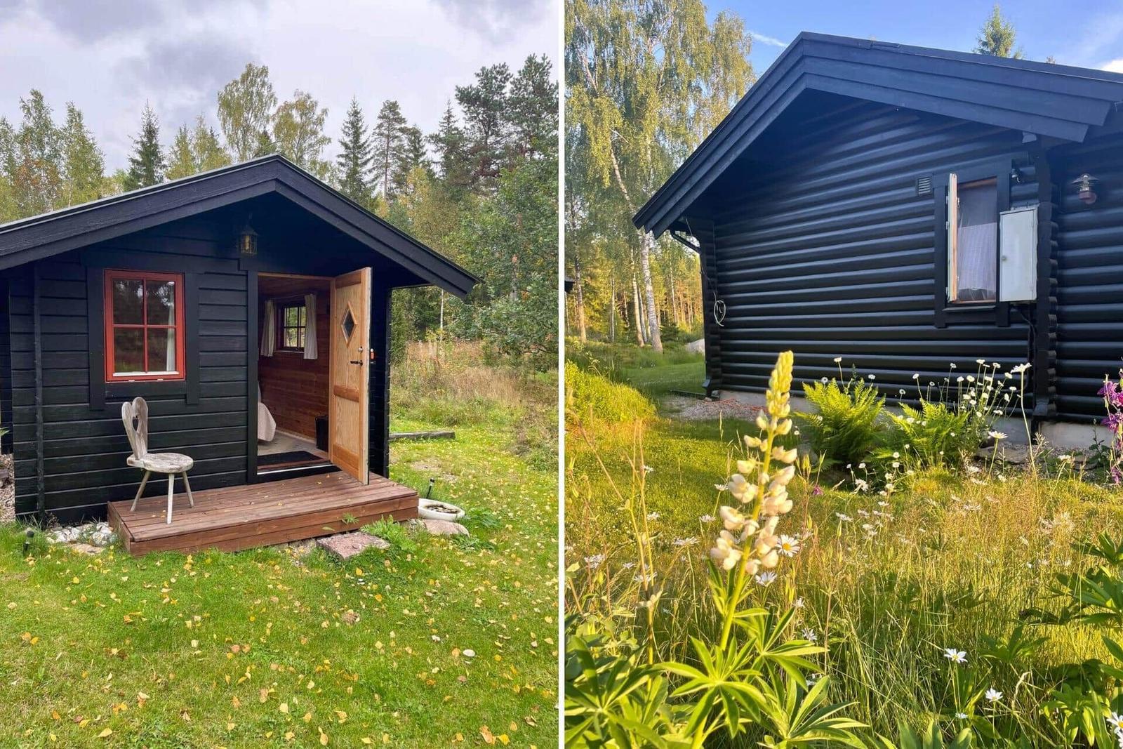 Schwarze Holzhütte mit offener Tür und Garten. Blick auf das Gebäude mit Blumen.