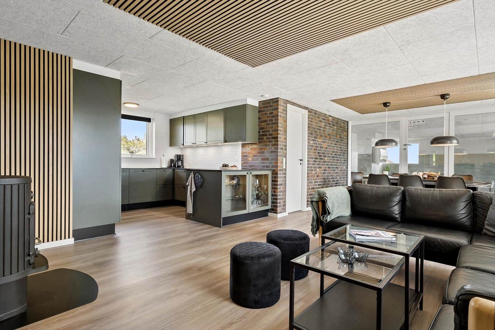 Living and kitchen area with wooden floor, sofa, and kitchen island.